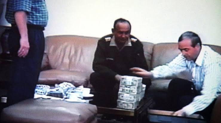 Fotograma de archivo: Vladimiro Montesinos entrega fajos de dinero durante una reunión filmada en secreto.